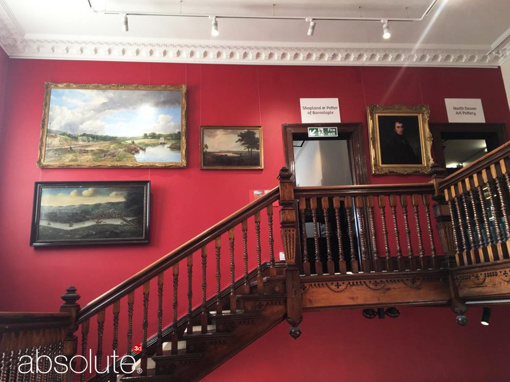 Artworks secured to a wall using Ryman hangers and H Track art hanging system in The Museum of Barnstaple & North Devon.